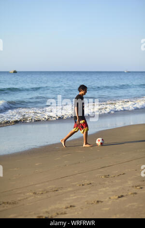 LOS ORGANOS, PERU - 30. AUGUST 2013: Unbekannter junger Mann spielen Fußball auf dem Sandstrand am 30. August 2013 in Los Organos, Peru. Stockfoto