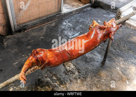 Manila, Philippinen - 5. März 2019: Calavite Straße in Salvacion Teil der Stadt. Nahaufnahme des rot-braun gebratene Ferkel am Spieß, genannt Lechon Baboy, gerade Stockfoto