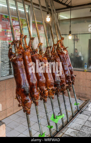 Manila, Philippinen - 5. März 2019: Calavite Straße in Salvacion Teil der Stadt. Acht ganze Ferkel gebraten auf Spits, genannt Lechon Baboy, angezeigt w Stockfoto