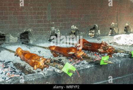 Manila, Philippinen - 5. März 2019: Calavite Straße in Salvacion Teil der Stadt. Nahaufnahme von drei Ferkel auf Spits, genannt Lechon Baboy, sind noch roas Stockfoto