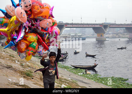 DHAKA, BANGLADESCH - 28. JANUAR 2019: Der Junge ist verkaufen Farbe Luftballons in den schmutzigen, grau Port in Dhaka Stockfoto