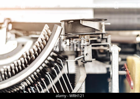 Beförderung Block mit Buchstaben in einer alten mechanischen Schreibmaschine. Nahaufnahme, offene Blende. Stockfoto