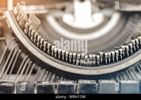 Beförderung Block mit Buchstaben in einer alten mechanischen Schreibmaschine. Nahaufnahme, offene Blende. Stockfoto