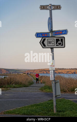 Eine einsame Frau Spaziergänge auf der Promenade in Fishguard, Wales, UK. Mittwoch 28. August 2019 Stockfoto