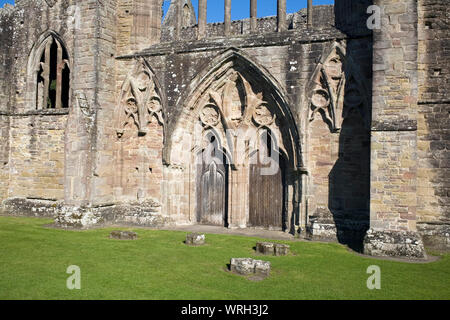 West Front von Tintern Abbey mit hölzernen Türen auf warmen August Nachmittag Stockfoto