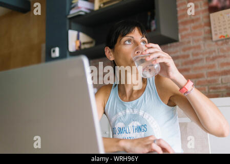 Frau mit Laptop zu Hause arbeiten Stockfoto