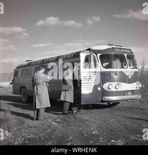 1950, historische, zwei Männer an Bord eines Sightseeing Bus von Alaska Hyway Touren in Anchorage, Alaska, USA von Gray Line, ein weltweit führender Anbieter von Stadtrundfahrten in 1910 von Louis Bush in Washington D. C. gegründet Stockfoto