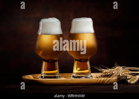 Zwei Gläser kalter golden Bier und Weizen ährchen auf dunklem Hintergrund. Stockfoto