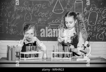 Die Verbesserung ihrer Studie Fähigkeiten. Studiengruppe in Chemie Labor. Kleine Schule Kinder holding Röhrchen während der Studie. Kleine schulmädchen Durchführung Studie Experiment in der Chemie. Stockfoto