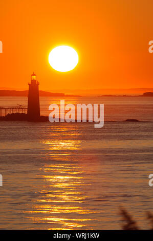 Ram Island Ledge Leuchtturm mit einem Sonnenaufgang reflektiert das Meerwasser, Portland, Maine. Stockfoto