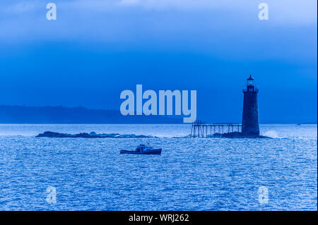 Blauer morgen mit einem Hummer Boot vorbei an den Ram Island Riff Lighthouse, Portland, Maine, USA. Stockfoto