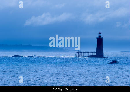 Angeln Boot vorbei an Ram Island Ledge Leuchtturm in Portland, Maine, USA Stockfoto