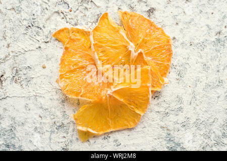 Gesunde hausgemachte Frucht Chips von Orange auf grauem Hintergrund. Bio Diät essen. Die vegane Ernährung. Getrocknete Früchte. Vegetarische auf pflanzlicher Basis snack Konzept. Zu Stockfoto