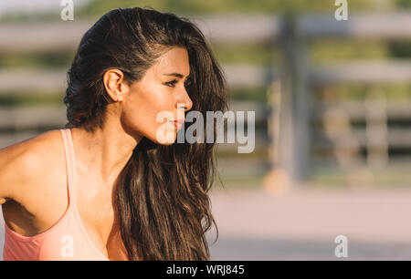 Latin Frau und brunette Oberflächen trainieren, tragen rosa Top und schwarzen leguins. Stockfoto