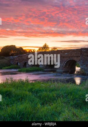 Sturminster Marshall, Dorset, Großbritannien. 10. September 2019. UK Wetter. Eine spektakuläre feurigen Sonnenuntergang am historischen Weiße Mühle Brücke am River Stour in der Nähe von Sturminster Marshall in Dorset. Foto: Graham Jagd-/Alamy leben Nachrichten Stockfoto