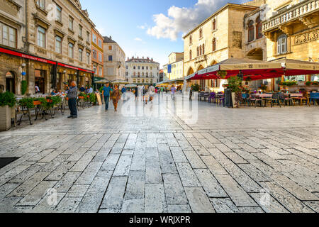 Touristen und Einheimische Pass von Geschäften und Cafés, wie Sie ihren Tag auf Völker Platz im Diokletianpalast in Split Kroatien starten Stockfoto