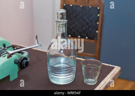 Glas Flasche Wasser mit Glas. Eine Flasche Schnaps auf den Tisch. Frisches und sauberes Trinkwasser in der Kanne und Glas. Antike Antike vintage Stockfoto