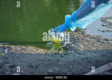 Close-up Umweltschützer Hand eines Forschers in einem Prozess der Entnahme einer Probe von kontaminiertem Wasser aus einem See Stockfoto