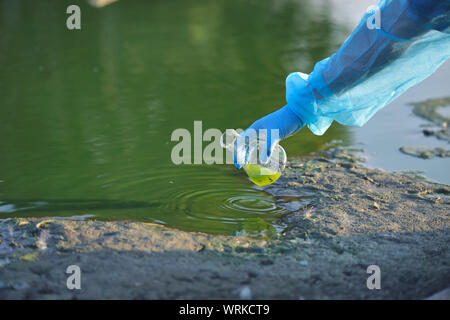 Close-up Umweltschützer Hand eines Forschers in einem Prozess der Entnahme einer Probe von kontaminiertem Wasser aus einem See Stockfoto