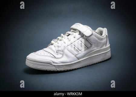 Weiße basketball Sneakers auf blauen Hintergrund mit schwarzem vignete. Stockfoto
