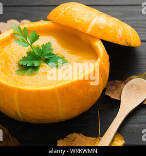 Kürbis creme Suppe über dunklen Holztisch. Detailansicht mit Herbst Dekoration. Platz schoß Stockfoto