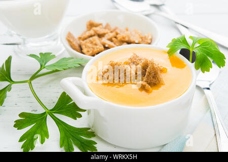 Herbst traditionelle amerikanische Kürbis und Karotten Cremesuppe mit Krümel und Petersilie. Licht schoss Stockfoto