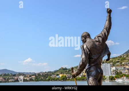 Montreux, Schweiz - 26. Juli 2019: berühmte Statue von Freddie Mercury, der Sänger der berühmten Band Queen. Stadt durch den Genfer See im Hintergrund. Beliebte Touristenattraktion. Platz kopieren, ein Platz für Text. Stockfoto