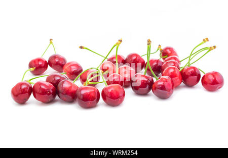 Gruppe der schönen frischen roten Kirschen auf weißem Hintergrund. Stockfoto