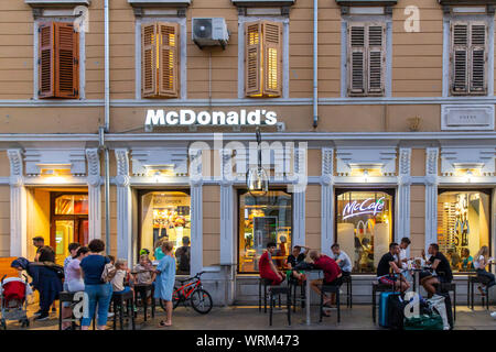 Von Rijeka Korzo McDonalds auf der Haupteinkaufsstraße. Kunden essen ihre Mahlzeiten draußen an einem warmen Sommerabend. Rijeka, Kroatien, 2019 Stockfoto