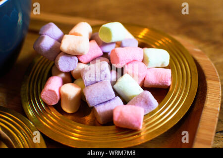 Viele kleine bunte Marshmallows auf einem goldenen Platte. Stockfoto