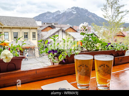 Genießen Sie Bier auf der Terrasse des Banff Ave Brewing Co. in Banff, Alberta Stockfoto
