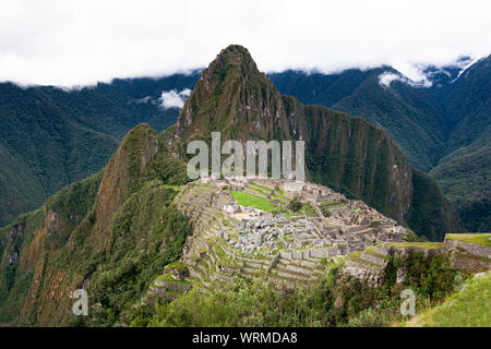 Machu Picchu Ruinen mit bewölktem Himmel auf der Rückseite Stockfoto