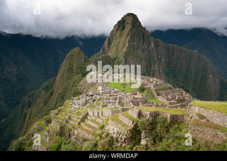 Machu Picchu Ruinen mit bewölktem Himmel auf der Rückseite Stockfoto