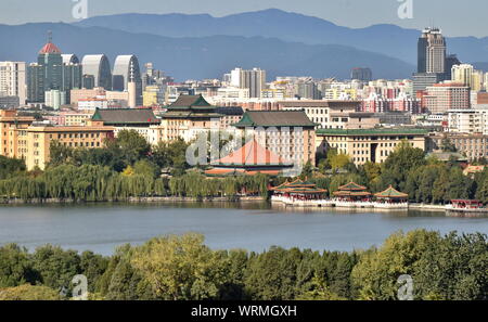 Peking saubere Stadt Skyline von Qianhai See von Beihai Park mit einem Kontrast von moderner und traditioneller Architektur und die Berge im Rücken, China Stockfoto