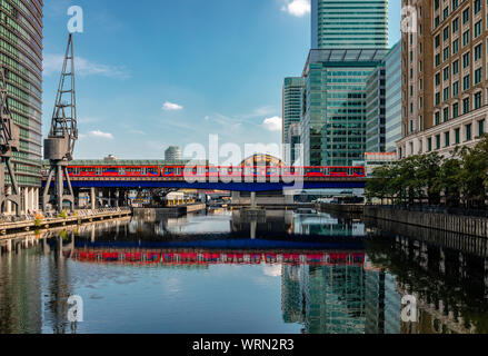 London/Großbritannien - 27. August 2019: Die Docklands Light Railway spiegelt sich auf den Gewässern des Nordens Dock, in Canary Wharf Entwicklung. Stockfoto