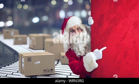 Santa Claus gibt an, ein Raum für die Christimas vorhanden, mit bereit Pakete auf Hintergrund Stockfoto