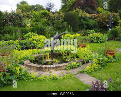 Chenies Manor versunkenen Garten mit Skulpturen von Jenny Pickford und Alan Biggs. grünen Pflanzen im Frühsommer. Stockfoto