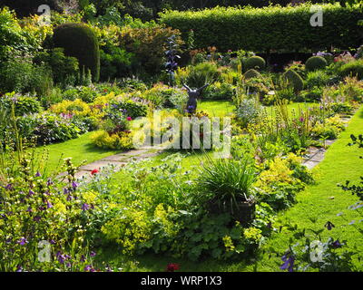 Chenies Manor versunkenen Garten mit Skulpturen von Jenny Pickford und Alan Biggs. grünen Pflanzen im Frühsommer. Stockfoto