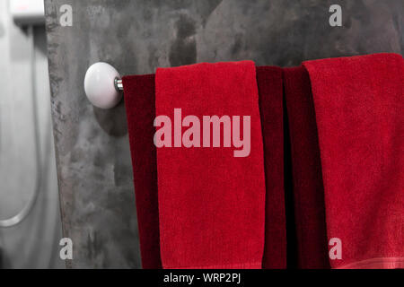 Zwei rote Handtücher im Badezimmer auf einem Trockner. Counter Bad modern. Luxuriöses und elegantes Design Badezimmer mit einem konkreten Mauern. Stockfoto