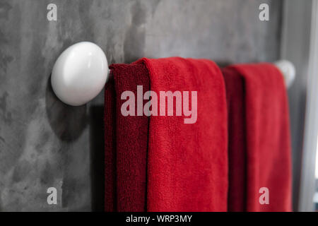 Zwei rote Handtücher im Badezimmer auf einem Trockner. Counter Bad modern. Luxuriöses und elegantes Design Badezimmer mit einem konkreten Mauern. Stockfoto