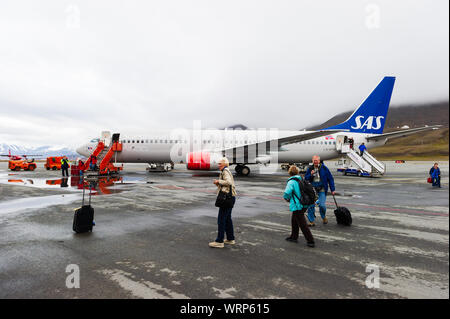 LONGYEARBYEN, Svalbard, Norwegen - 25. JULI 2010: Passagiere aussteigen im Freien von einer kommerziellen jet Flugzeug. Stockfoto