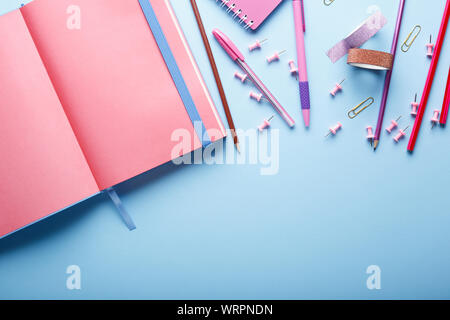 Notebook- und Schulbedarf auf blauem Hintergrund. Zurück zu Schule. Flach. Stockfoto
