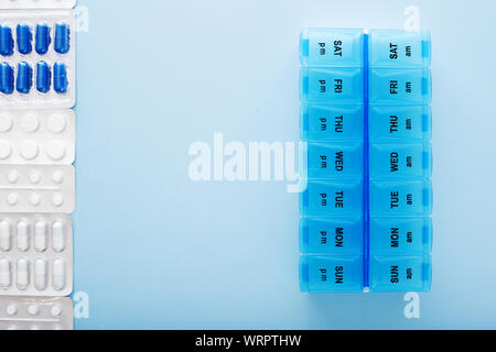 Kunststoff blau 14 tag Pille Box mit Pillen auf blauem Hintergrund. Ansicht von oben. Stockfoto