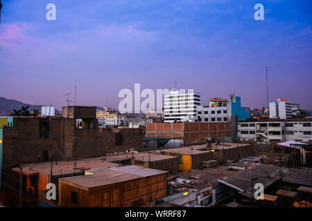 Blick auf den Sonnenuntergang an der Lima Altstadt vom Dach eines Hauses in Breña Stockfoto