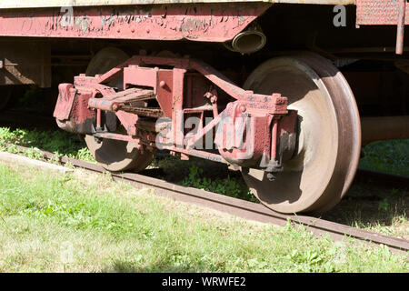 In der Nähe der Räder auf einer alten aus dem 19. Jahrhundert Eisenbahn, Auto mit Verwitterten aussehen und sich verschlechternden rote Farbe Stockfoto