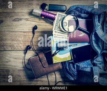 Notwendig Objekt für Reisende in Jeans Handtasche auf hölzernen Tisch Stockfoto