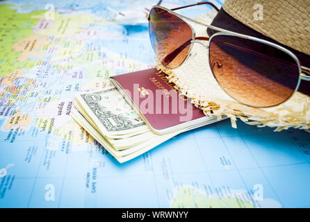 Travel Concept, Hut, Sonnenbrille, Pass, Geld und Flugzeuge, die auf der Weltkarte Stockfoto