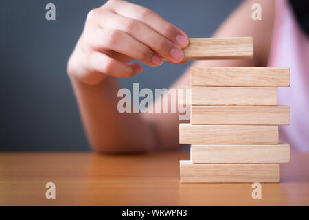 Die Mädchen Hand stapeln Holz- Bausteine. Business Development Konzept. Stockfoto