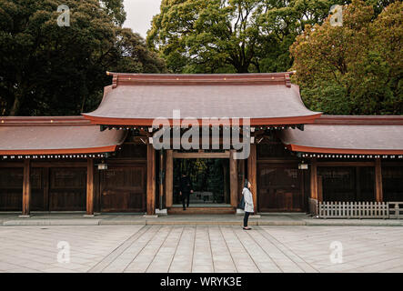 DEC 5, 2018 Tokyo, Japan - Meiji Jingu-Schrein historische hölzerne Tor und Korridor mit Touristen und Wald Hintergrund - wichtigste Heiligtum der Japan c Stockfoto