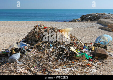 Schutt, Müll oder Müll an einem Strand in Numana in der Nähe von Ancona an der Adria in Italien mit Treibholz und Plastikflaschen es umweltschädliche Stockfoto